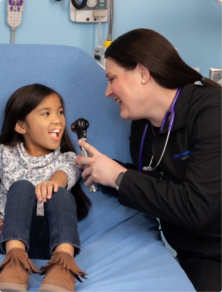 APP_Pediatric_Modality Female pediatric advanced practice provdider employee smiles and examines a young girl in the hospital room